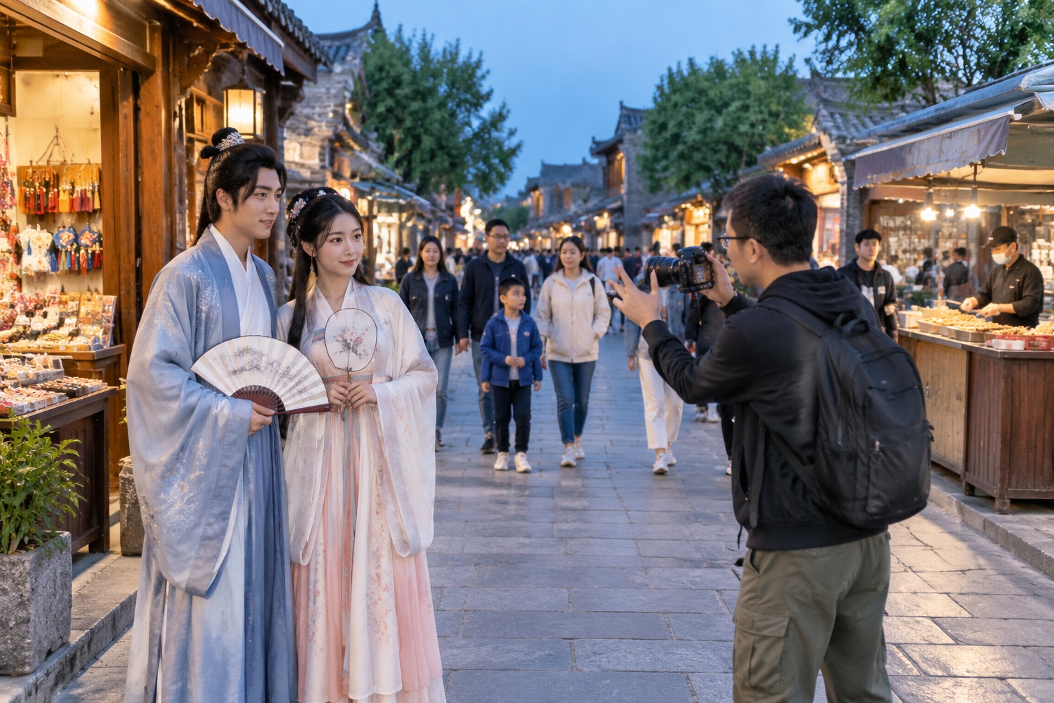 Hanfu-clad visitors pose for a photographer as evening crowds pass through Luoyang's old-city streets.